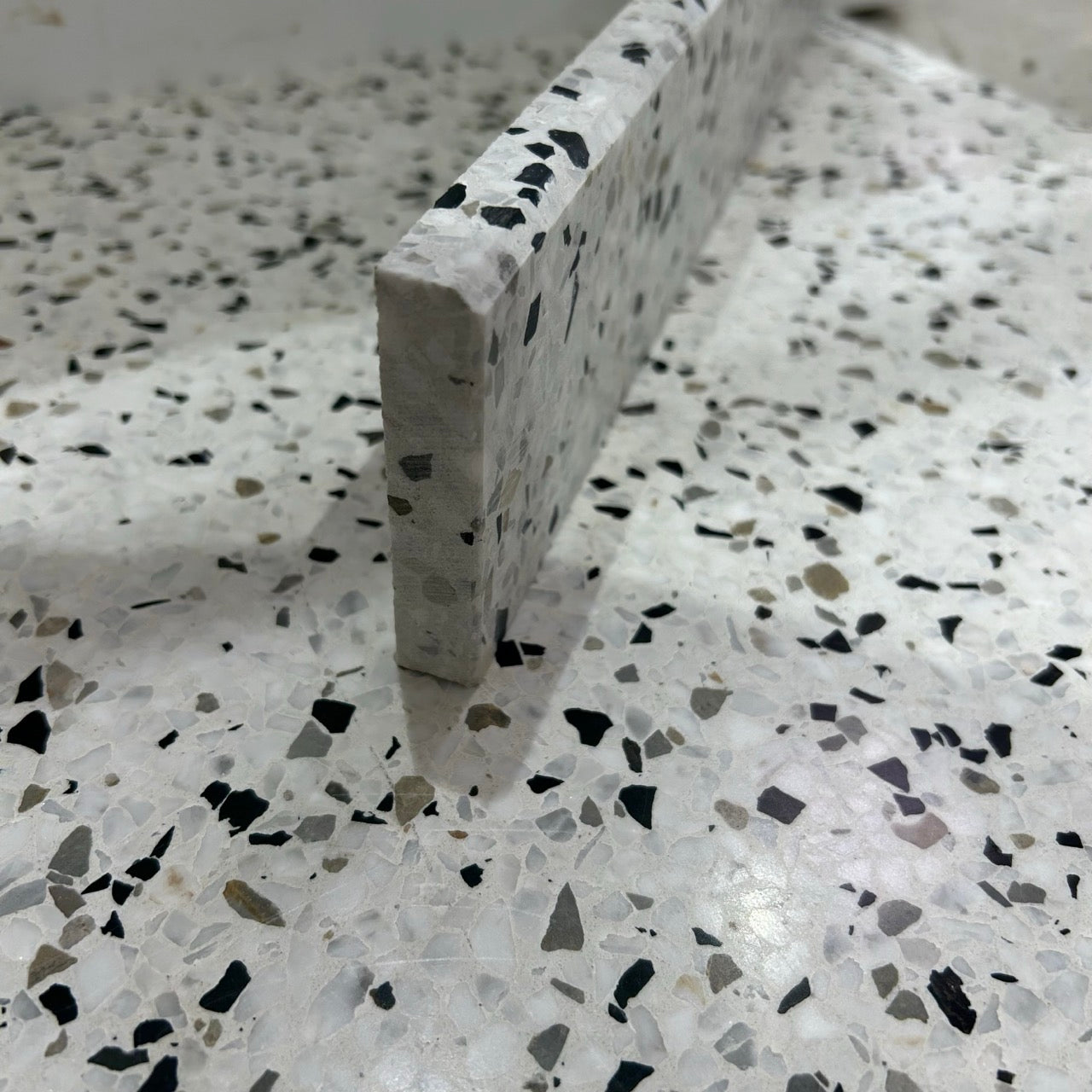 Terrazzo 1910 med sort, hvidt og gråbrunt mix Sokkelkant