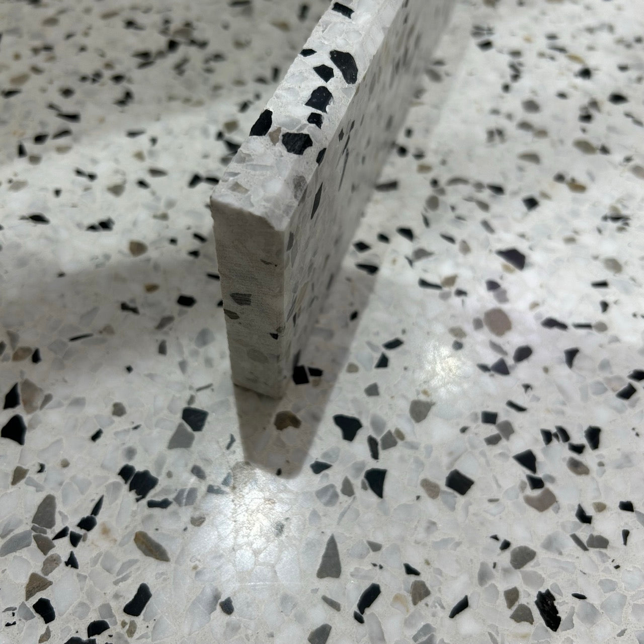 Terrazzo 1910 med sort, hvidt og gråbrunt mix Sokkelkant