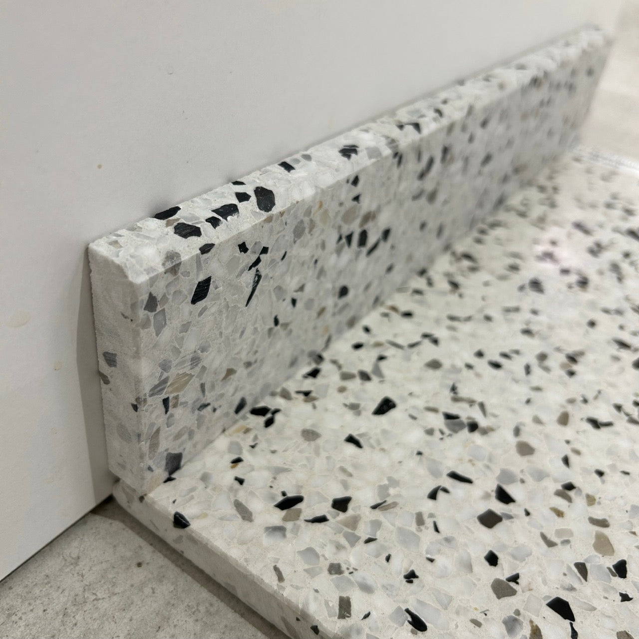 Terrazzo 1910 med sort, hvidt og gråbrunt mix Sokkelkant