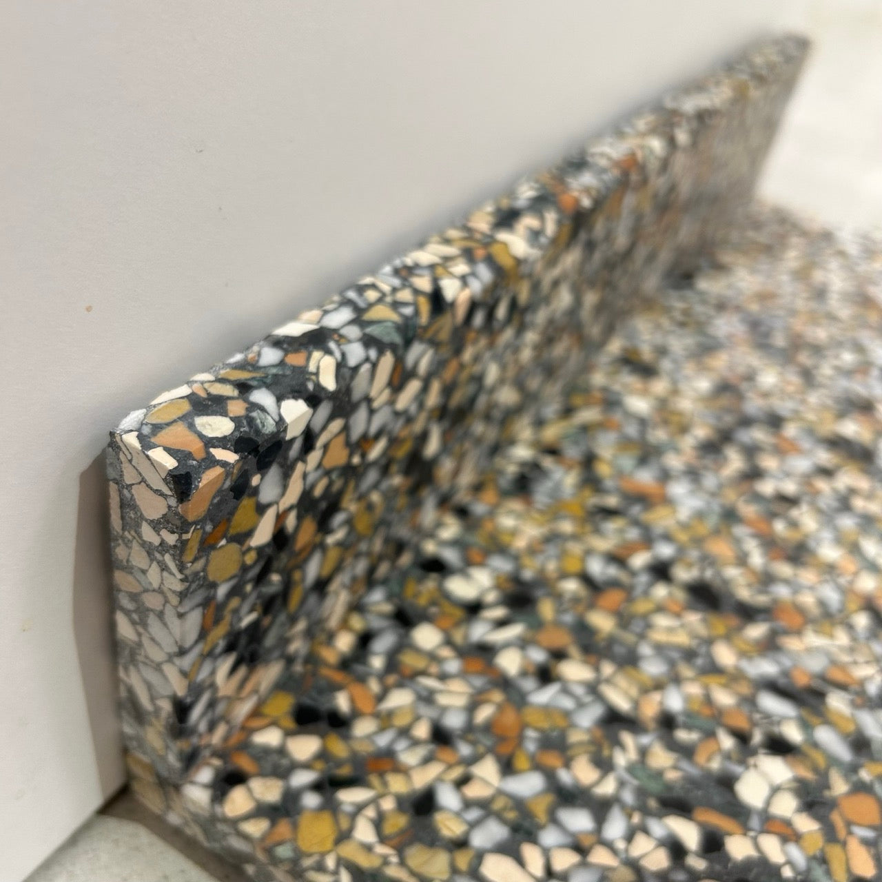 Terrazzo 8810 med mørkt, grønt og orange mix Sokkelkant