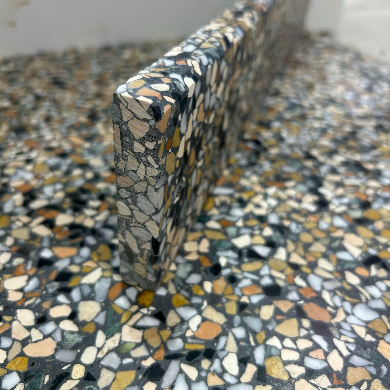 Terrazzo 8810 med mørkt, grønt og orange mix Sokkelkant
