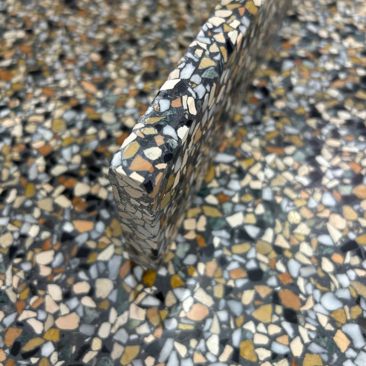 Terrazzo 8810 med mørkt, grønt og orange mix Sokkelkant