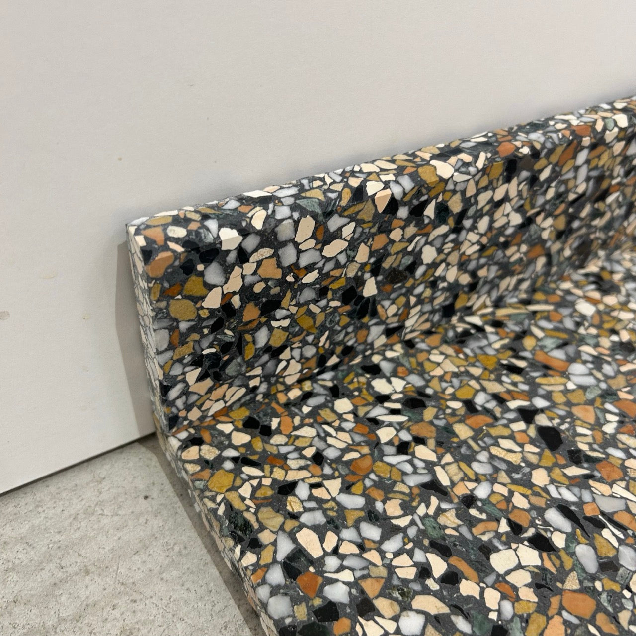 Terrazzo 8810 med mørkt, grønt og orange mix Sokkelkant